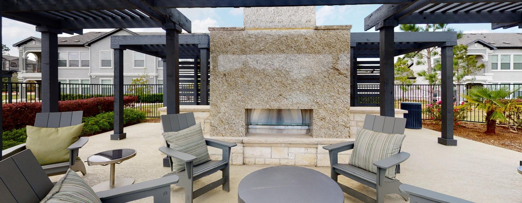 a patio with a fireplace and chairs