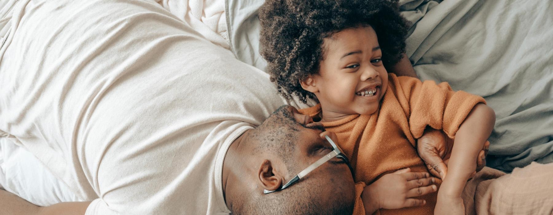 a person and a child lying in bed