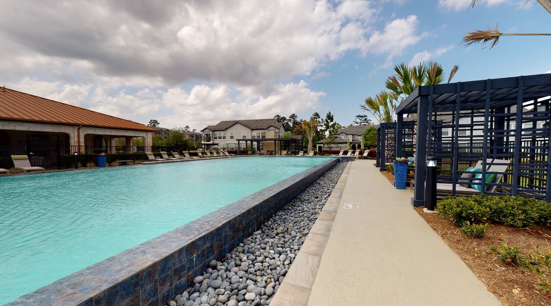 a large long pool with covered seating areas