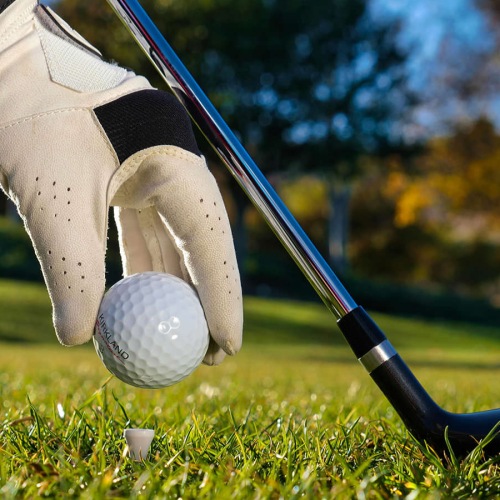 man placing golf ball on a tee